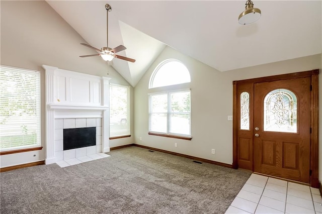704 Canter St, Raymore, MO 64083 - entrance foyer featuring plenty of natural light, a ceiling fan, a tiled fireplace, high vaulted ceiling, and light carpet