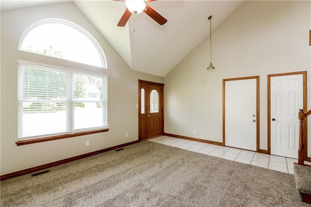 704 Canter St, Raymore, MO 64083 - foyer with light carpet, high vaulted ceiling, ceiling fan, and light tile patterned floors
