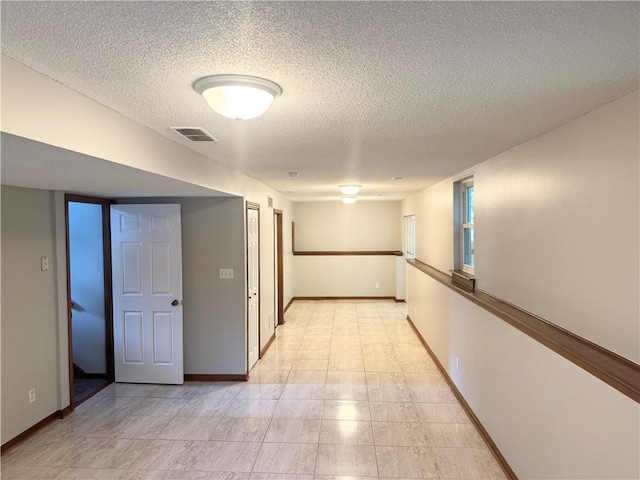 704 Canter St, Raymore, MO 64083 - hallway featuring a textured ceiling and light tile patterned flooring