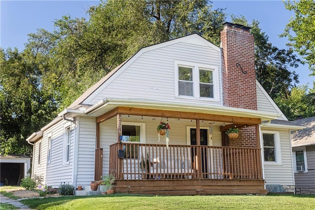2026 E 70th Ter, Kansas City, MO 64132 - view of front of house featuring a porch, a chimney, a front yard, and a gambrel roof