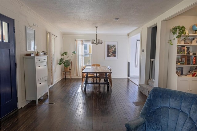 2026 E 70th Ter, Kansas City, MO 64132 - dining space with dark wood finished floors, a chandelier, a textured ceiling, and ornamental molding