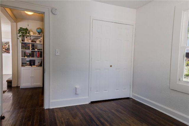 2026 E 70th Ter, Kansas City, MO 64132 - unfurnished bedroom with dark wood finished floors and baseboards