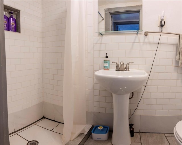 2026 E 70th Ter, Kansas City, MO 64132 - bathroom featuring tile walls and tiled shower