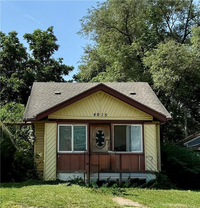 4015 E 68th Ter, Kansas City, MO 64132 - bungalow featuring a shingled roof and a front lawn