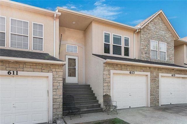 613 S Woodson Ln, Gardner, KS 66030 - view of front of house featuring stone siding, stucco siding, a garage, and driveway