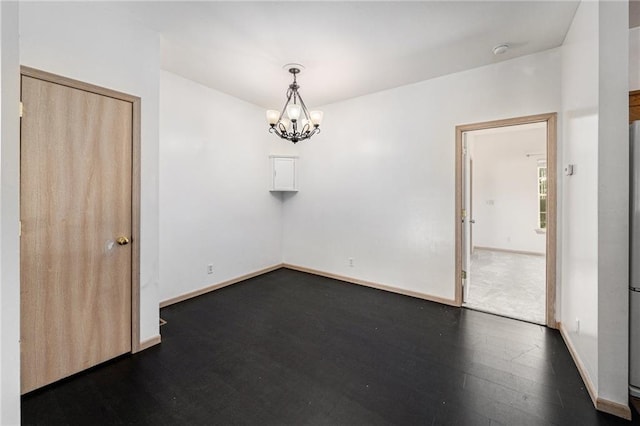 613 S Woodson Ln, Gardner, KS 66030 - unfurnished room featuring dark wood finished floors, a chandelier, and a smoke detector