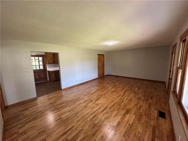 533 Utah St, Leavenworth, KS 66048 - empty room with wood finished floors and a textured ceiling