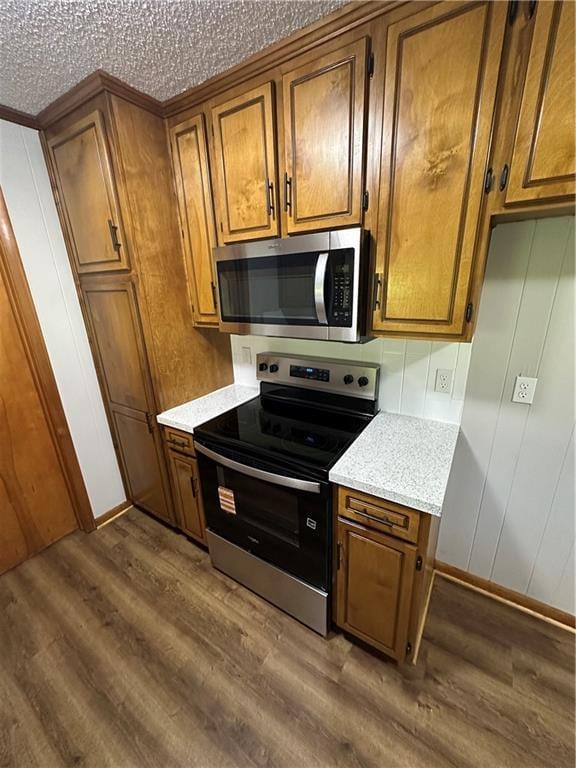 533 Utah St, Leavenworth, KS 66048 - kitchen with appliances with stainless steel finishes, brown cabinets, wood finished floors, and light countertops