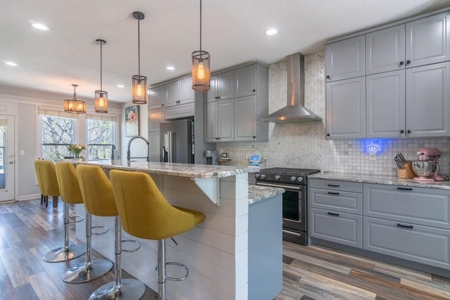 4603 N 111th St, Kansas City, KS 66109 - kitchen with wall chimney range hood, stainless steel appliances, gray cabinets, dark wood finished floors, and recessed lighting