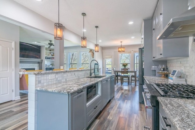 4603 N 111th St, Kansas City, KS 66109 - kitchen with appliances with stainless steel finishes, extractor fan, gray cabinetry, wood finished floors, and tasteful backsplash