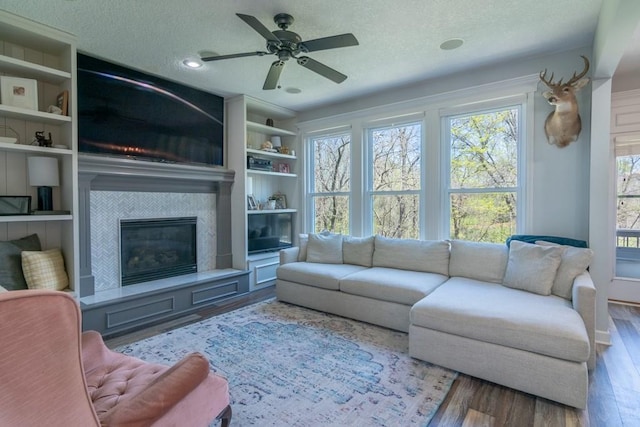 4603 N 111th St, Kansas City, KS 66109 - living room with a textured ceiling, wood finished floors, a glass covered fireplace, and ceiling fan