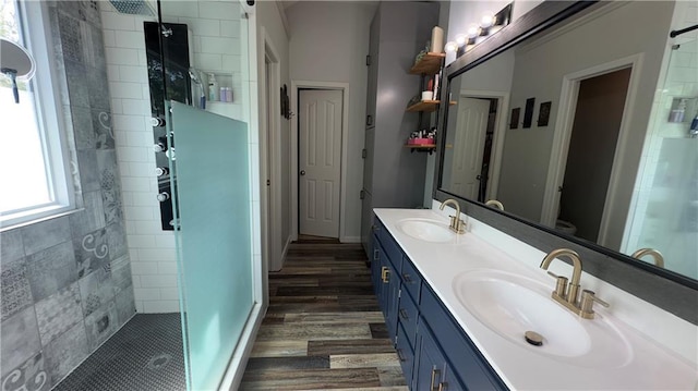 4603 N 111th St, Kansas City, KS 66109 - full bathroom featuring a tile shower, double vanity, and wood finished floors