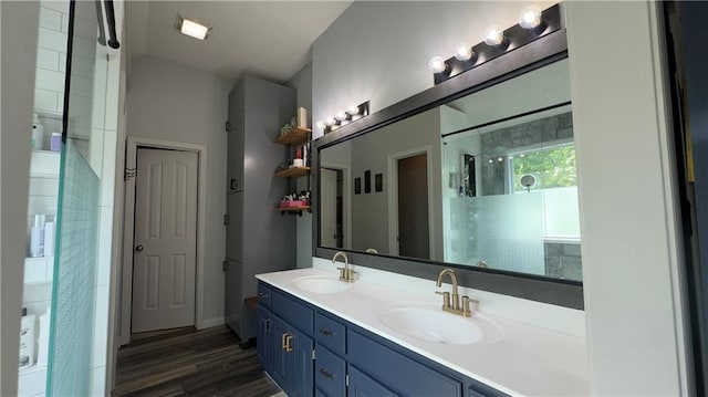 4603 N 111th St, Kansas City, KS 66109 - bathroom featuring double vanity, a shower stall, and wood finished floors