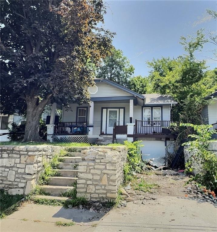 5829 Jackson Ave, Kansas City, MO 64130 - view of front of property featuring covered porch, stairway, and an attached garage