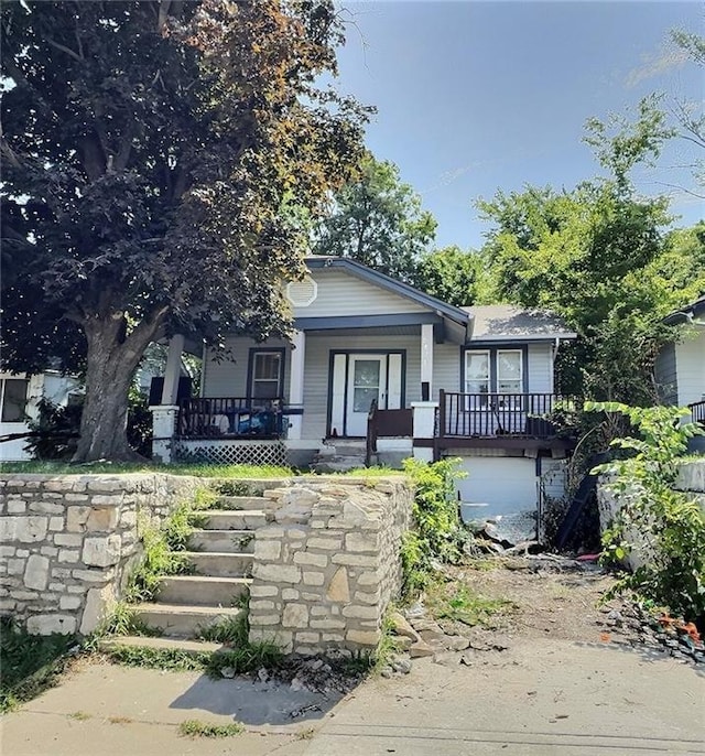 5829 Jackson Ave, Kansas City, MO 64130 - view of front of property featuring covered porch, stairway, and an attached garage