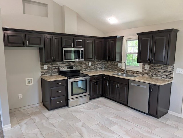 2205 S Owing St, Oak Grove, MO 64075 - kitchen with stainless steel appliances, lofted ceiling, tasteful backsplash, dark cabinetry, and light stone counters