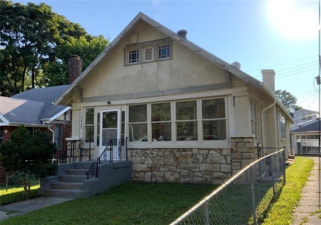 6623 Olive St, Kansas City, MO 64132 - bungalow with a chimney, stone siding, and stucco siding