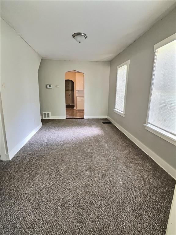 8409 Park Ave, Kansas City, MO 64132 - unfurnished room featuring arched walkways and carpet floors