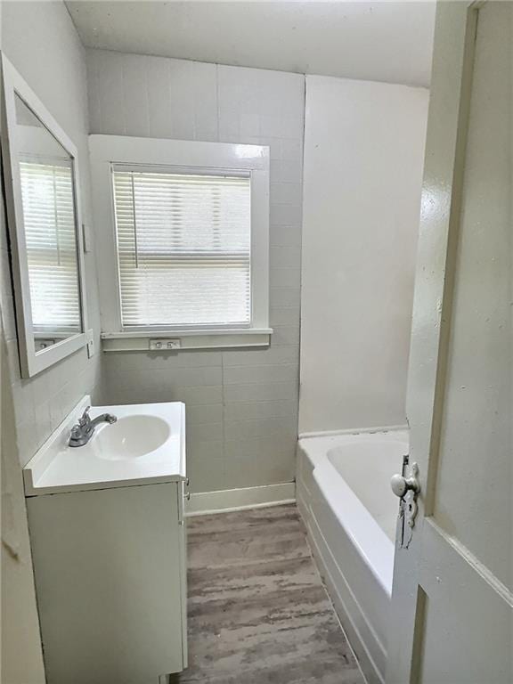 8409 Park Ave, Kansas City, MO 64132 - bathroom with vanity, a bath, and wood finished floors