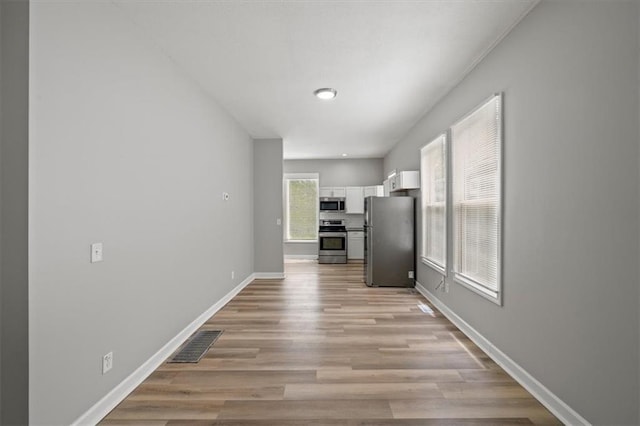 3543 Flora Ave, Kansas City, MO 64109 - unfurnished dining area featuring light wood-style floors and baseboards