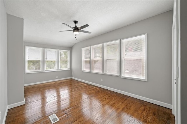 3543 Flora Ave, Kansas City, MO 64109 - spare room featuring a ceiling fan, wood-type flooring, and a textured ceiling