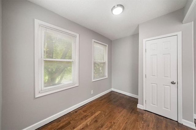 3543 Flora Ave, Kansas City, MO 64109 - unfurnished bedroom featuring baseboards and dark wood finished floors