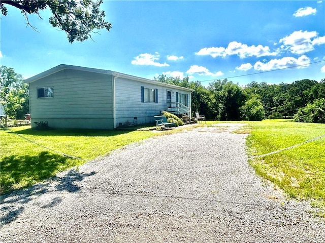 14444 E Quail Rd, Nevada, MO 64772 - view of home's exterior with a lawn, crawl space, and gravel driveway