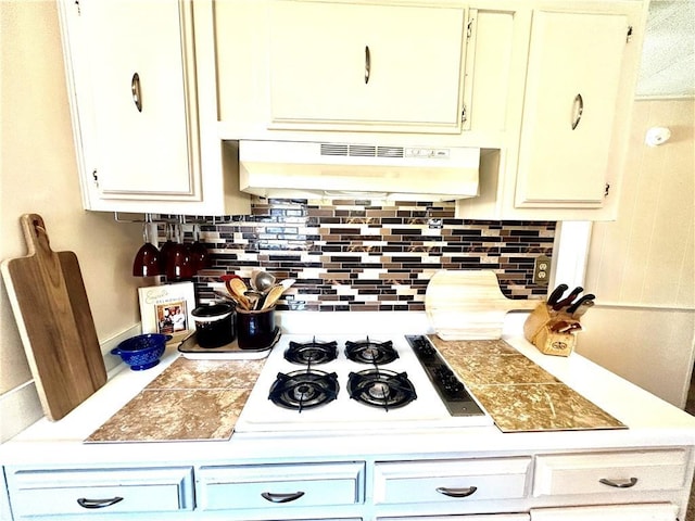 14444 E Quail Rd, Nevada, MO 64772 - kitchen with under cabinet range hood, white gas stovetop, backsplash, and light countertops