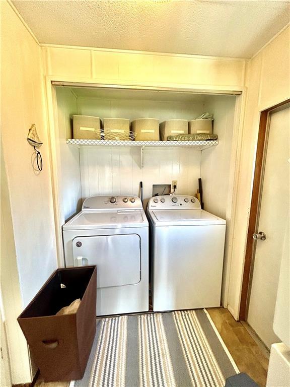 14444 E Quail Rd, Nevada, MO 64772 - laundry room with independent washer and dryer, a textured ceiling, and wood finished floors