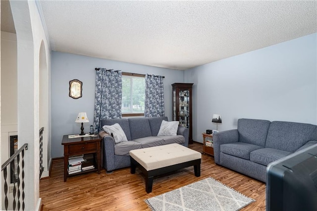 303 W S St, Spring Hill, KS 66083 - living area with a textured ceiling, wood finished floors, and a fireplace