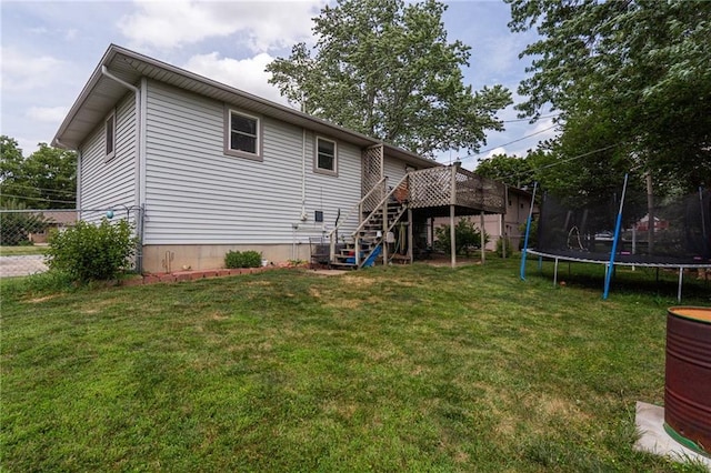 303 W S St, Spring Hill, KS 66083 - rear view of property featuring stairway, a trampoline, a yard, and a wooden deck