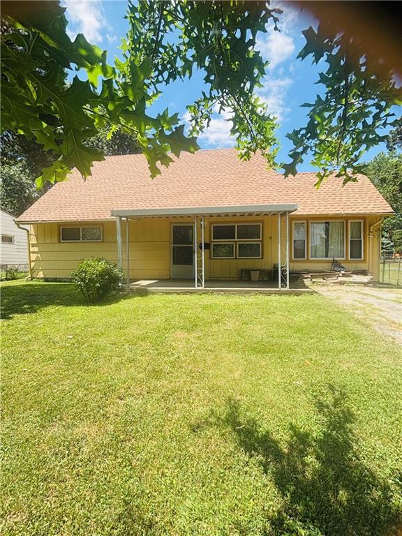 2506 S 48th Ter, Kansas City, KS 66106 - rear view of property featuring a lawn, a patio area, and roof with shingles