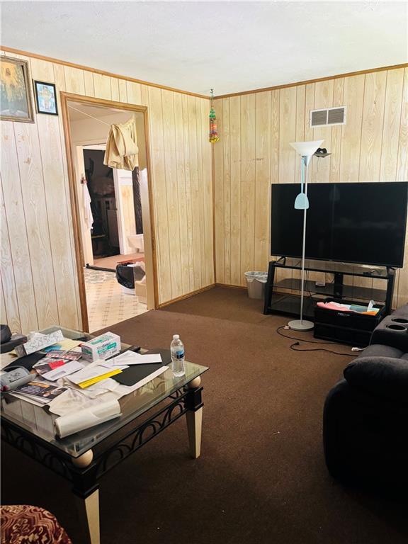 2506 S 48th Ter, Kansas City, KS 66106 - carpeted living room featuring wooden walls and baseboards