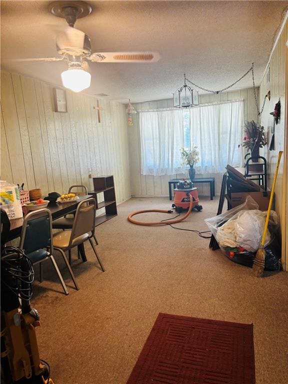 2506 S 48th Ter, Kansas City, KS 66106 - playroom featuring carpet, wooden walls, a textured ceiling, and a ceiling fan