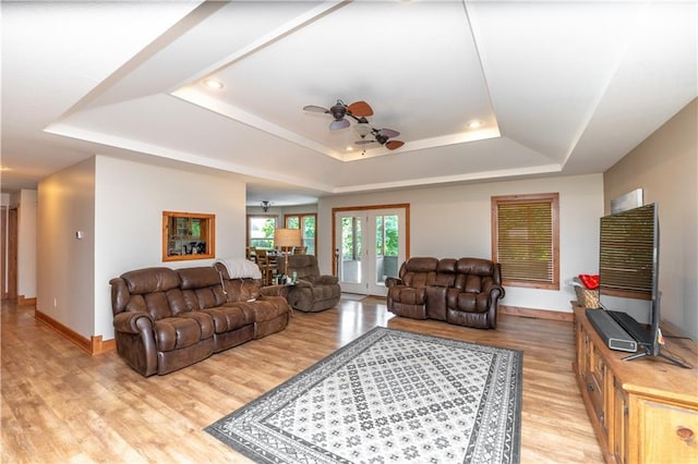 29309 E State Route B, Archie, MO 64725 - living area with a tray ceiling, ceiling fan, and light wood-style flooring