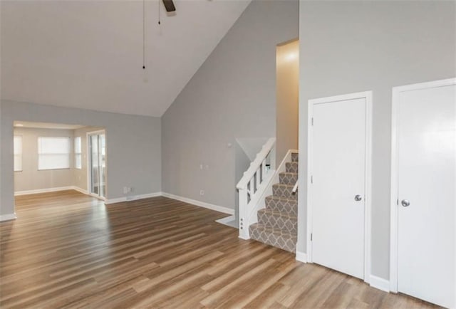 127 E Nelson Cir, Olathe, KS 66061 - unfurnished living room featuring stairway, vaulted ceiling, wood finished floors, and a ceiling fan