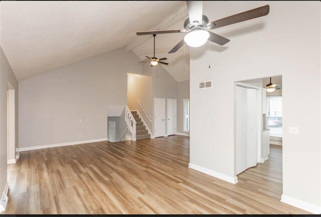 127 E Nelson Cir, Olathe, KS 66061 - unfurnished living room with high vaulted ceiling, light wood-type flooring, stairway, and ceiling fan