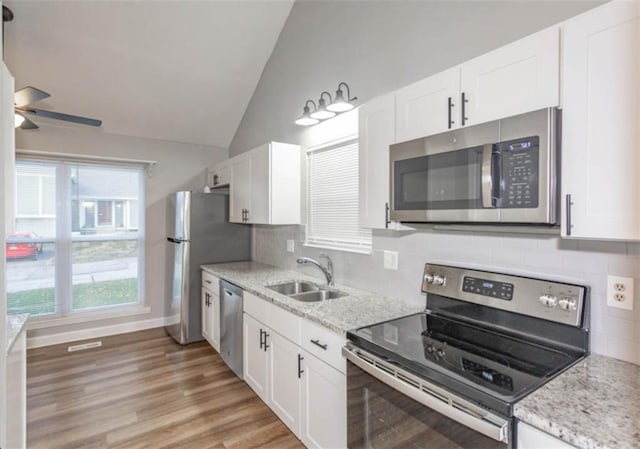127 E Nelson Cir, Olathe, KS 66061 - kitchen with stainless steel appliances, vaulted ceiling, a ceiling fan, white cabinetry, and tasteful backsplash