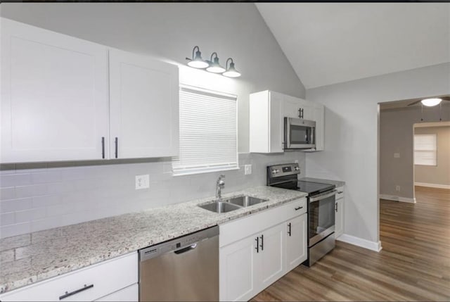 127 E Nelson Cir, Olathe, KS 66061 - kitchen with appliances with stainless steel finishes, decorative backsplash, lofted ceiling, white cabinets, and light wood finished floors