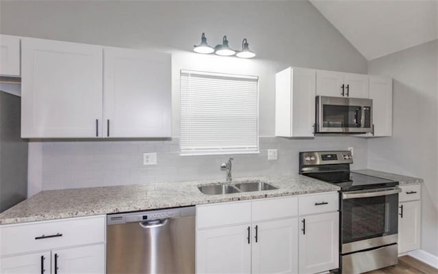 127 E Nelson Cir, Olathe, KS 66061 - kitchen with stainless steel appliances, decorative backsplash, white cabinetry, and vaulted ceiling