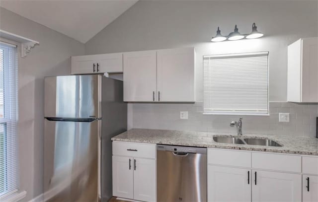 127 E Nelson Cir, Olathe, KS 66061 - kitchen featuring stainless steel appliances, white cabinetry, light stone countertops, decorative backsplash, and lofted ceiling