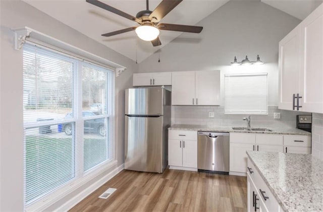 127 E Nelson Cir, Olathe, KS 66061 - kitchen featuring stainless steel appliances, ceiling fan, decorative backsplash, white cabinetry, and vaulted ceiling