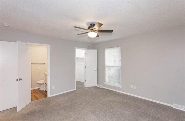 127 E Nelson Cir, Olathe, KS 66061 - unfurnished bedroom with carpet floors, a spacious closet, connected bathroom, and ceiling fan