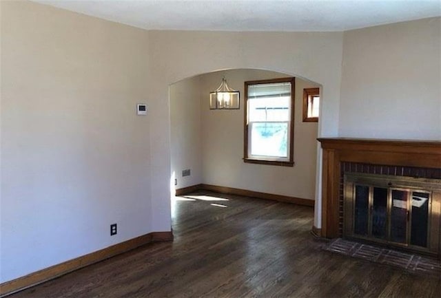 10216 W 60th Ter, Shawnee, KS 66203 - unfurnished living room with arched walkways, wood finished floors, and a fireplace