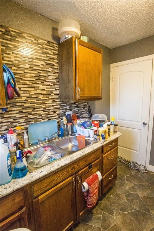 5521-3 Wabash Ave, Kansas City, MO 64130 - kitchen featuring tasteful backsplash, a textured ceiling, light countertops, and brown cabinets
