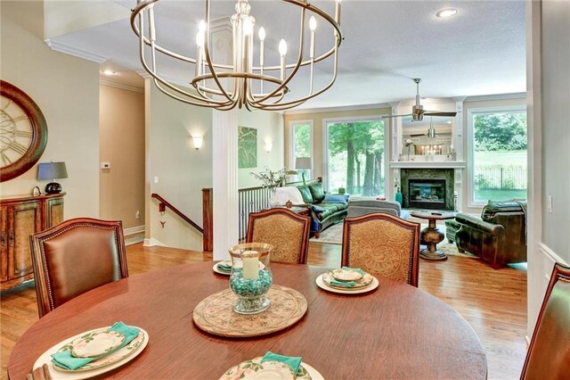 14780 S Glen Eyrie St, Olathe, KS 66061 - dining room with wood finished floors, ornamental molding, a chandelier, recessed lighting, and a glass covered fireplace