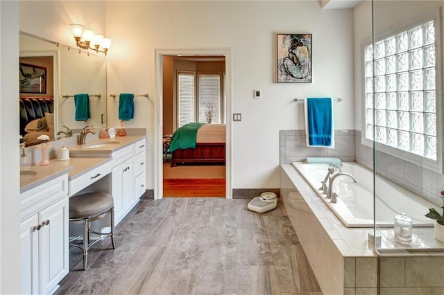 14780 S Glen Eyrie St, Olathe, KS 66061 - bathroom featuring double vanity, a bath, ensuite bathroom, and wood finished floors