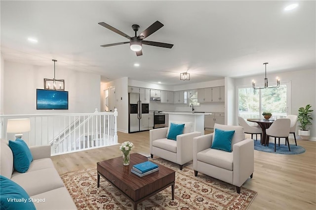 1101 SW Kingscross Rd, Blue Springs, MO 64014 - living area featuring a chandelier, light wood-style flooring, ceiling fan, and recessed lighting