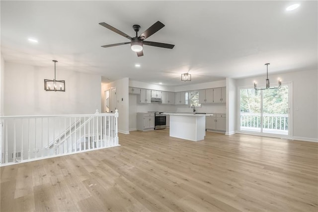 1101 SW Kingscross Rd, Blue Springs, MO 64014 - unfurnished living room featuring a chandelier, light wood-type flooring, recessed lighting, and ceiling fan