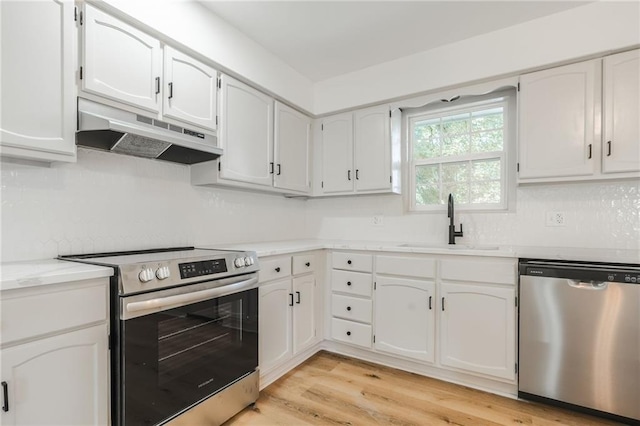 1101 SW Kingscross Rd, Blue Springs, MO 64014 - kitchen featuring stainless steel appliances, under cabinet range hood, white cabinetry, light countertops, and light wood-style flooring